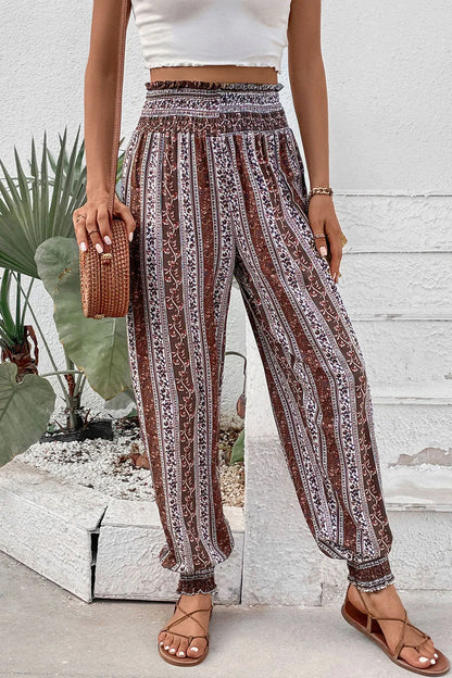 Person wearing patterned pants and a white top in an outdoor setting.