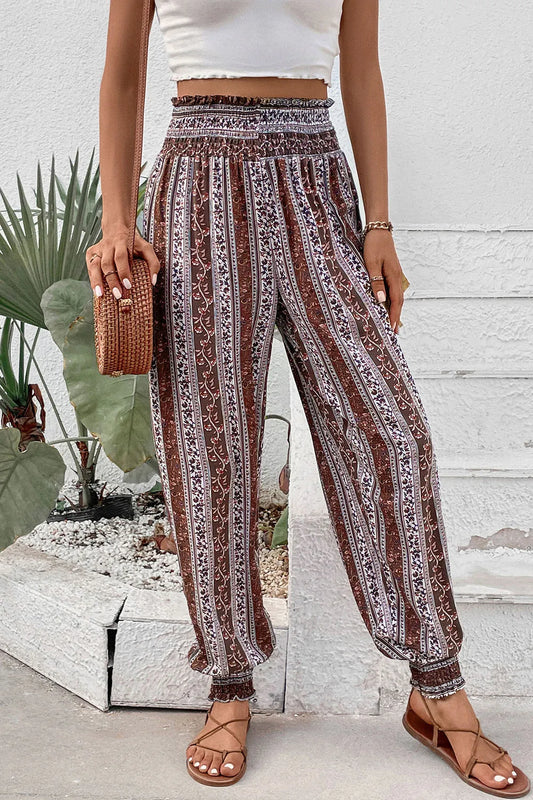Person wearing patterned pants and a white top in an outdoor setting.