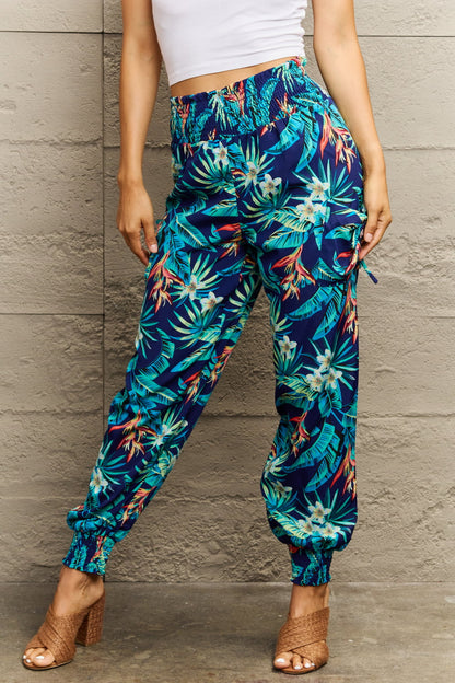 Person wearing tropical print pants against a gray wall
