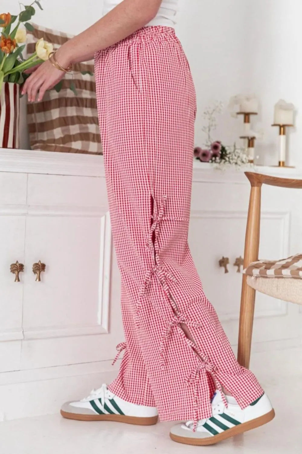 Person wearing red checkered pants with ruffles in a home setting